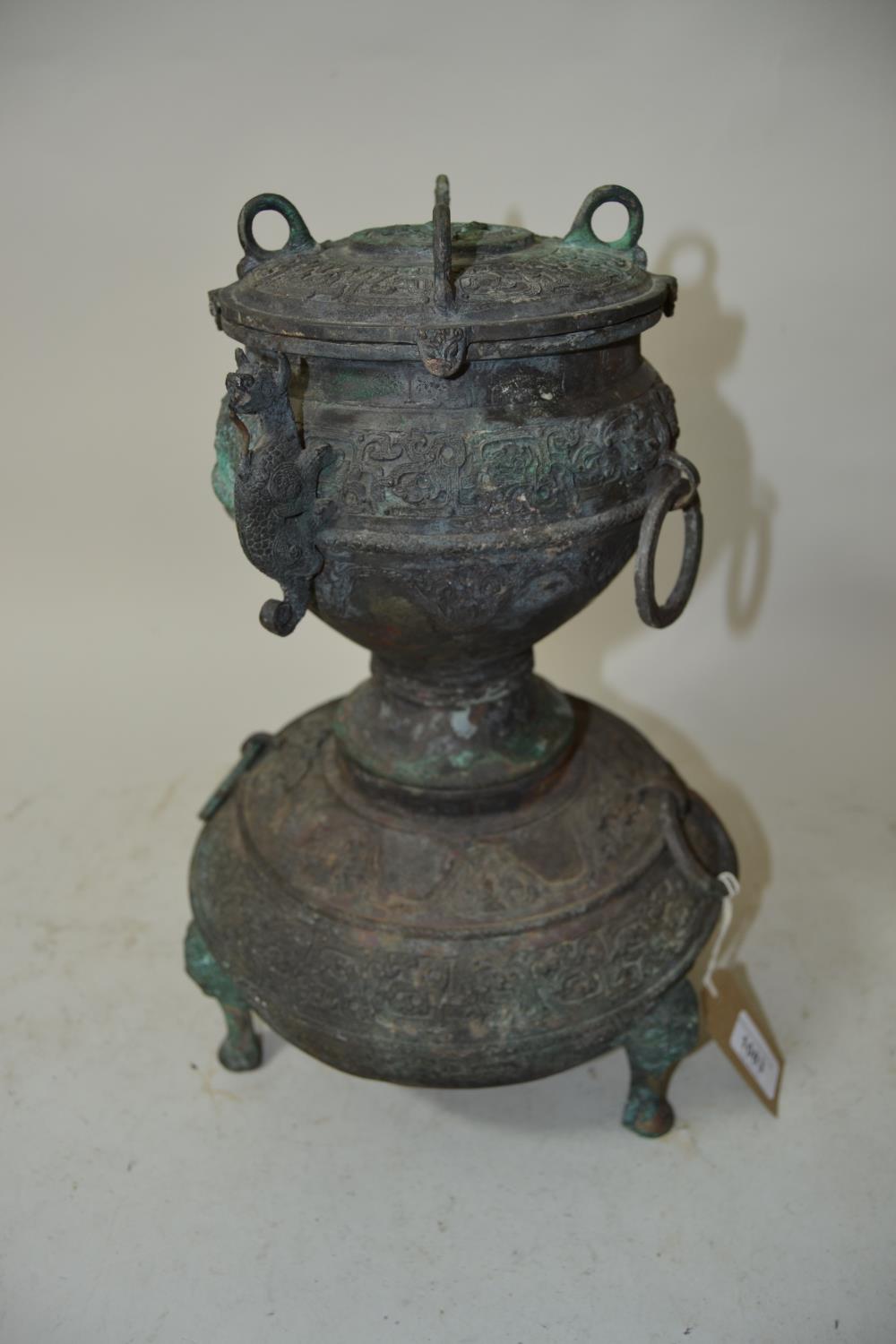 Asian dark and green patinated bronze three section food vessel with ring side handles, relief