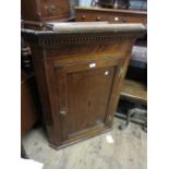 George III oak mahogany and inlaid hanging corner cabinet with a moulded and dentil cornice above