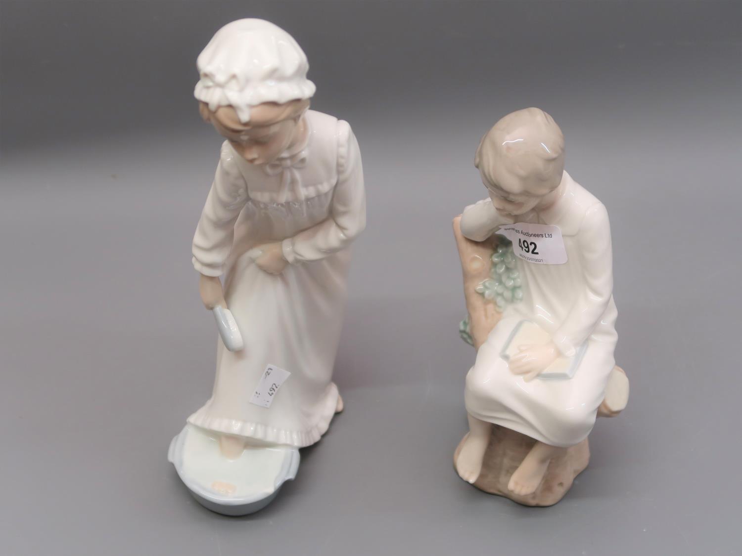 Two Lladro figures, a seated boy in a night dress and a Nao figure