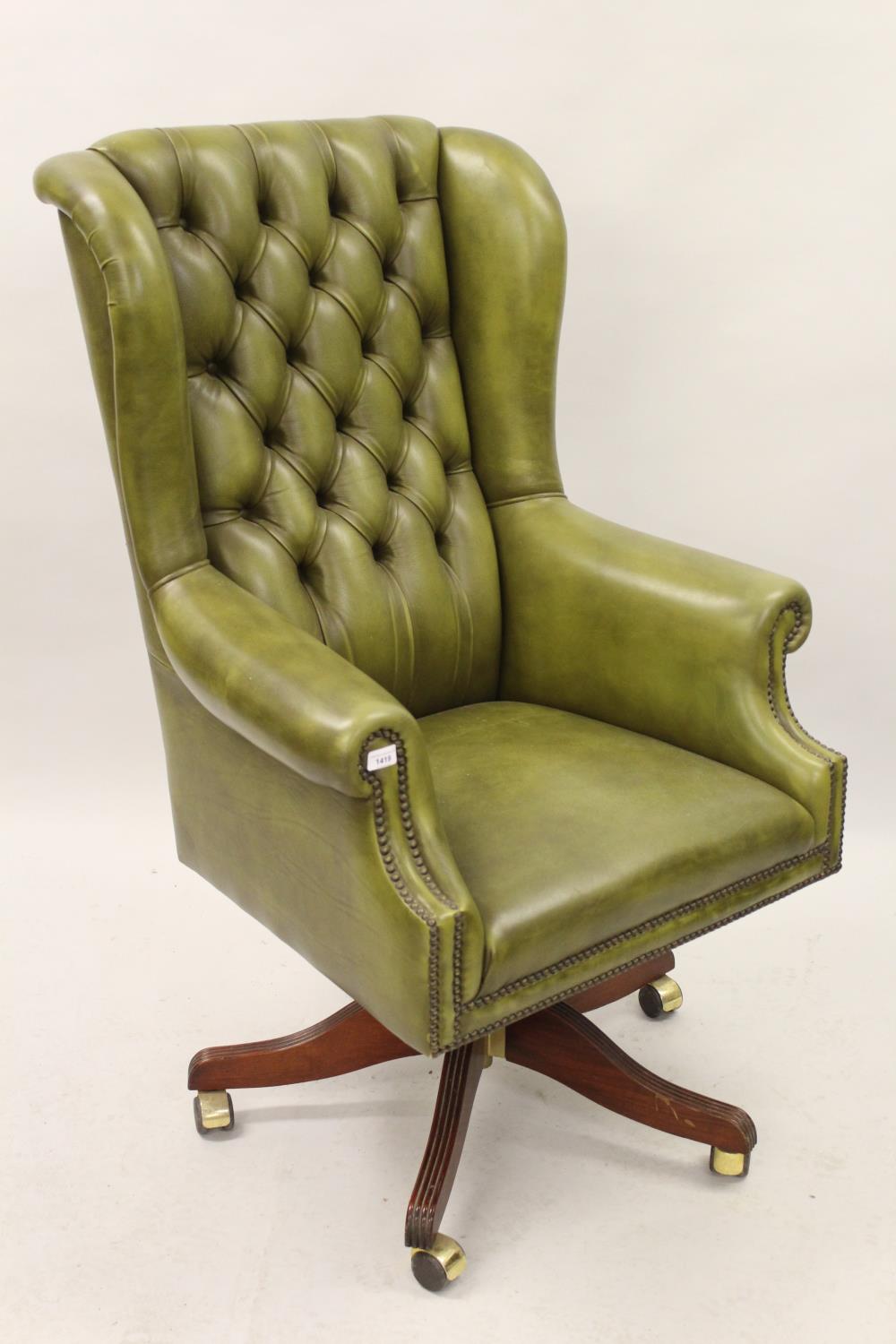 Late 20th Century green button leather upholstered office wing armchair, having five mahogany reeded