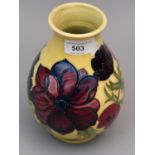 Modern Moorcroft baluster form pottery vase with tube lined floral decoration on a yellow ground,