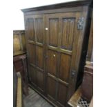 Good quality reproduction oak two door wardrobe with linen fold panel doors, raised on bun feet,