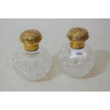 Pair of silver gilt and cross cut glass perfume decanters, the covers embossed with whispers design