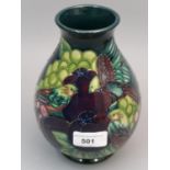 Modern Moorcroft baluster form pottery vase with tube lined, bird and fruit decoration on a dark