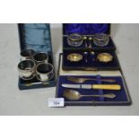 Three silver napkin rings, a plated napkin ring, cased silver and cut glass set of salts, a pair