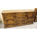 Good quality reproduction oak dresser base, the moulded top above an arrangement of five drawers and