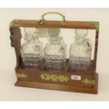 Oak and brass mounted three bottle tantalus Not marked Betjeman