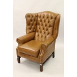 Pair of reproduction tan button leather upholstered wing back armchairs on square moulded supports