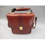 Brown leather bag with black trim, gold tone hardware, shoulder strap and carrying handle