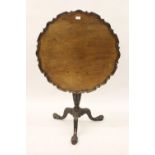 19th Century mahogany circular pedestal table in George III style, the shaped moulded tilt top above