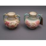 Near pair of Zsolnay Pecs squat baluster form two handled vases decorated with flowers on a cream