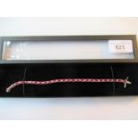 18ct White gold treated ruby and diamond line bracelet, the fifty two diamonds approximately 0.65ct,