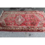 Hamadan rug of geometric design on wine ground, approximately 72ins x 40ins together with a small