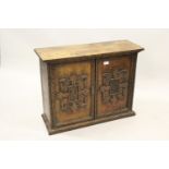 19th Century Continental walnut two door wall cupboard, the doors with applied carved armorials,