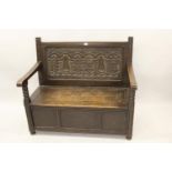 Late 19th / early 20th Century oak hall bench labelled Liberty, London, the carved panel back