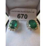 Pair of 18ct white gold oval emerald and diamond cluster ear studs, the emeralds approximately 3.