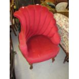 Red upholstered tub shaped drawing room chair with scallop shaped back, raised on cabriole front