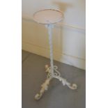 White painted wrought iron plant stand with spiral support and leaf form tripod base