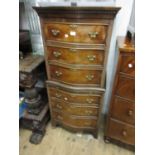 Reproduction walnut serpentine fronted tallboy with six drawers and a brushing slide, raised on