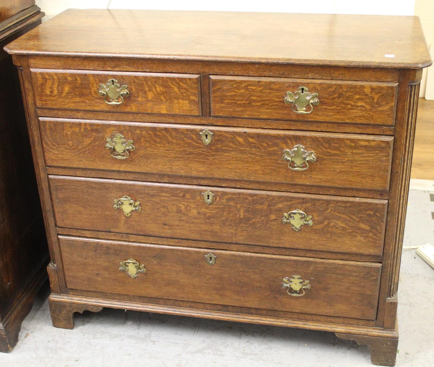 George III oak chest of two short and three long drawers with brass handles and escutcheons, flanked