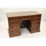 Victorian mahogany kneehole writing desk, the figured moulded top above nine drawers with knob
