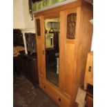 Small Arts and Crafts oak wardrobe, the moulded cornice above a centre mirrored door flanked by