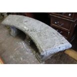 Weathered cast concrete bow shaped garden bench on three moulded supports