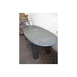 Contemporary wrought iron dining room table with an oval reconstituted stone top above four square