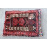 Group of three small Afghan carpet covered cushions and a modern machine woven Persian style rug,