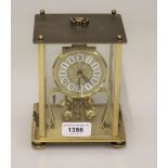 Modern brass three hundred day clock in a four glass case together with a modern mantel clock with