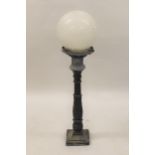 Pair of 1930's painted cast iron pillar lamps with white opaque glass globe form shades, 44ins high