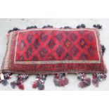 Afghan carpet fragment covered floor cushion with bead and shell work tassels, 24ins x 44ins