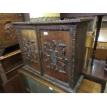 19th Century Continental walnut two door wall cupboard, the doors with applied carved armorials,