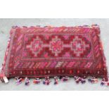 Large Afghan carpet fragment covered cushion with beadwork tassels, 45ins x 27ins