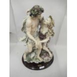 Late 20th Century resin group of two figures embracing, on a mahogany plinth, bearing label '