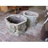 Pair of weathered reconstituted stone octagonal planters, decorated with cherubs and swags, 13ins