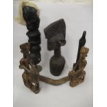 Four various African native wood carvings, together with a pair of similar carvings of figures on