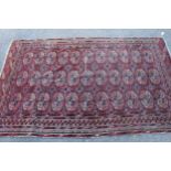 Small Turkoman rug with three rows of eleven gols, on a wine red ground with borders, 6ft x 3ft