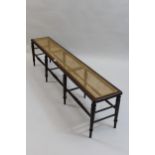 Late 19th / Early 20th Century long bench, with cane seat on eight turned tapering supports with