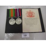 Two WWII Medals on ribbons, mounted to a card