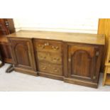 18th Century oak inverted breakfront dresser base, the three centre drawers with brass handles