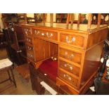 Reproduction yew wood pedestal desk, having tan leather inset top, above an arrangement of nine