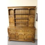 Good quality reproduction oak dresser, having moulded cornice above an arrangement of shelves and