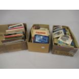 Two boxes containing a large quantity of various continental postcard booklets and a shoebox of