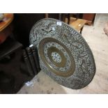 Large circular Benares brass top table on carved hardwood folding stand, the top with embossed