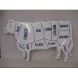 Tin plate butcher's sign in the form of a cow depicting various cuts of meat 32ins x 21ins