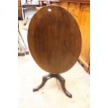 Oval mahogany tilt top pedestal table on turned column and tripod support