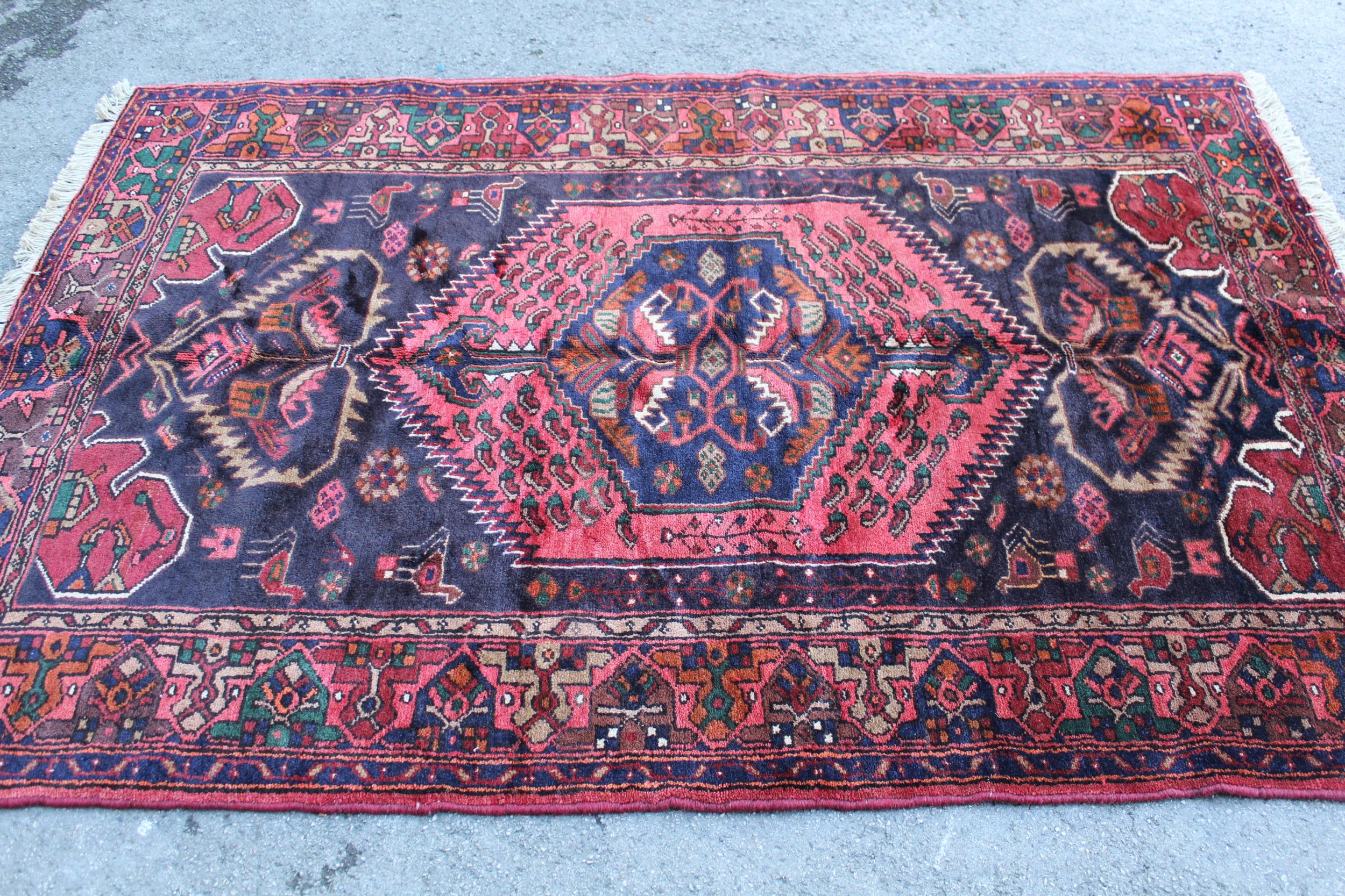 Zanjan rug with a medallion and all-over stylised design on a dark ground with borders, 2.06m x 1.4m