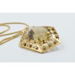 An unmarked high carat citrine and diamond set pendant of irregular pierced geometric form on an