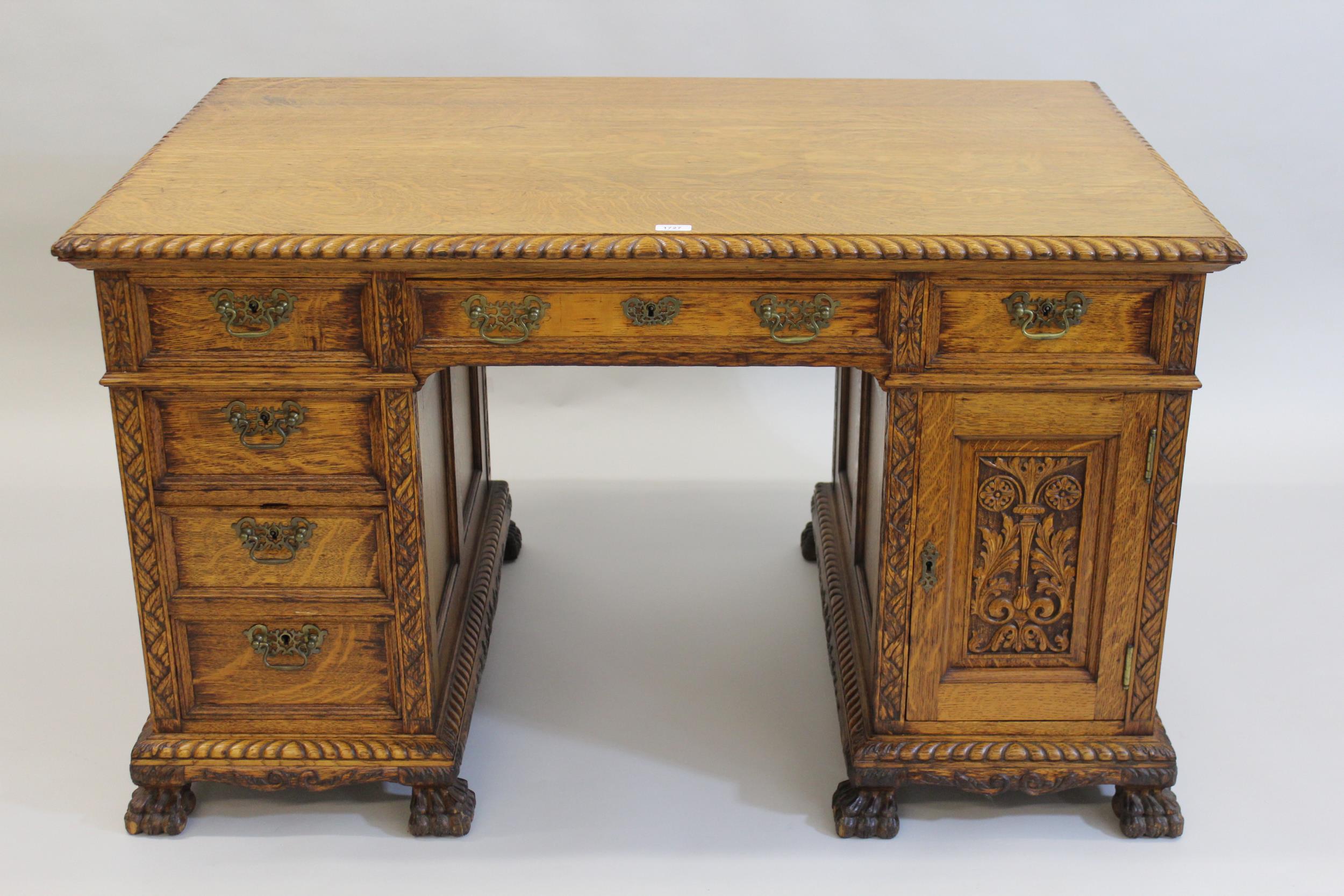 Early 20th Century honey oak pedestal partners desk, having moulded oak top, above an arrangement of